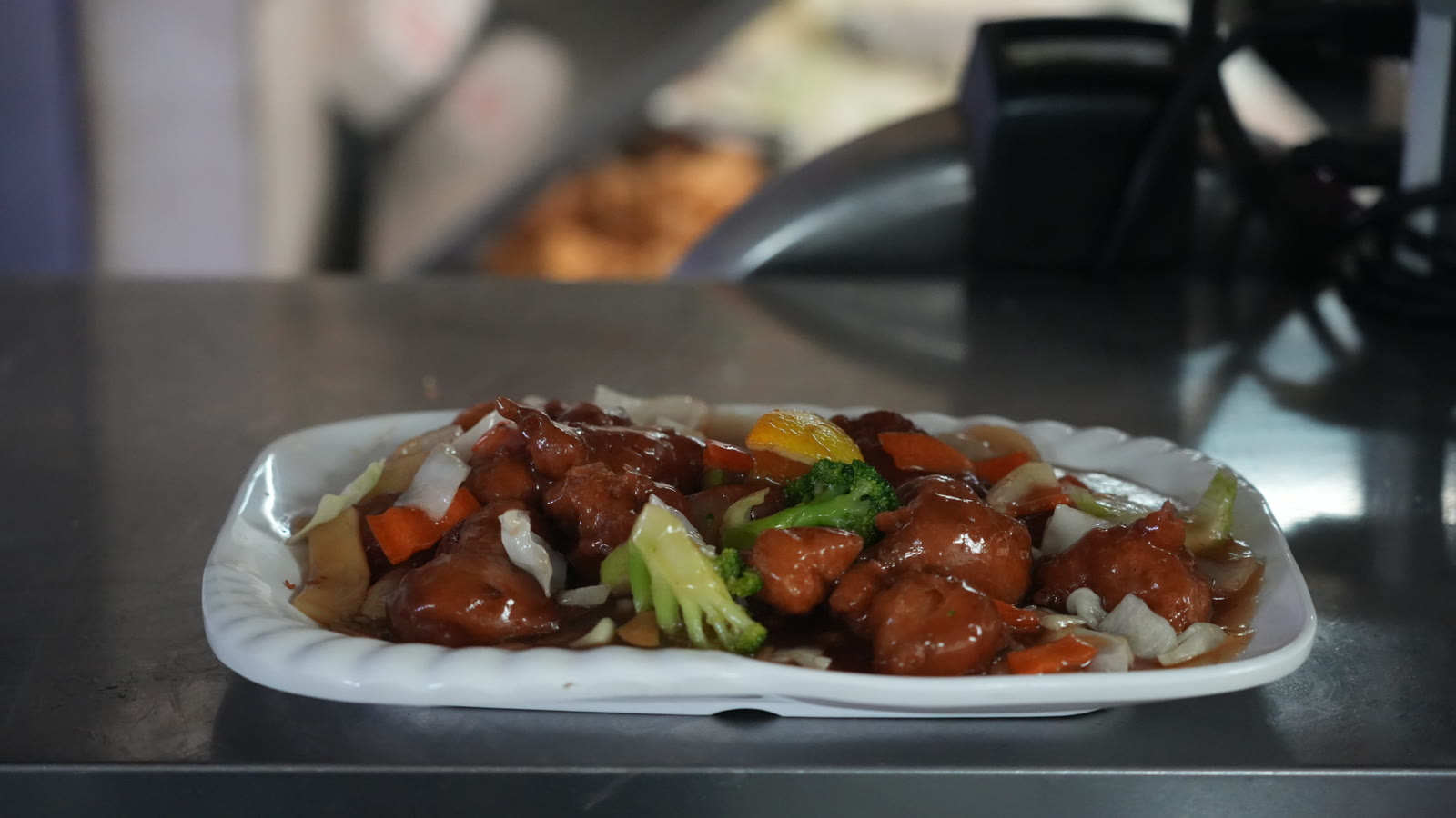 Glazed dish with broccoli and carrots on a white platter