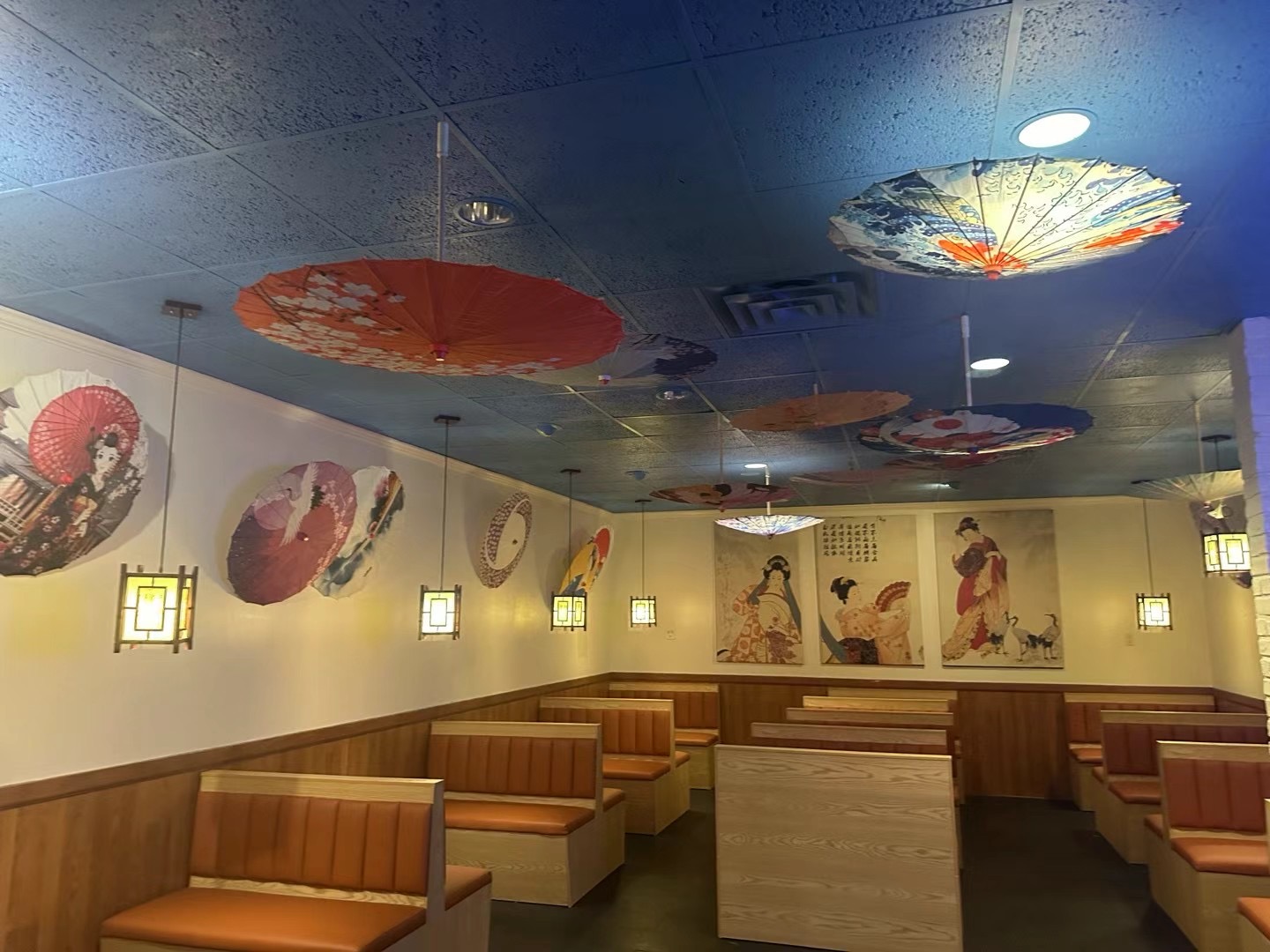 Polished dining room with Japanese parasols on the ceiling and warm booths