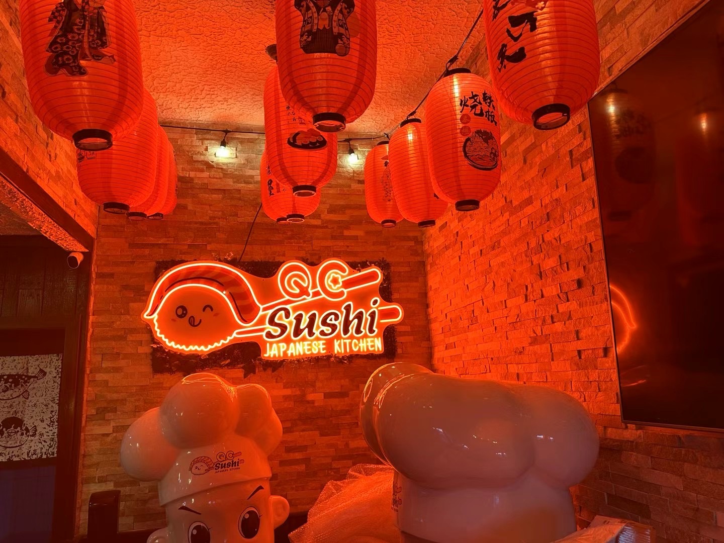 Interior with QC Sushi neon sign and red Japanese lanterns